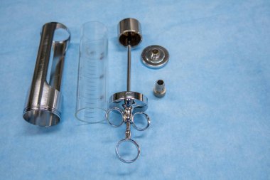 Parçalanmış ürolojik bir idrar kesesi şırıngası mavi bir işletim merkezinde yatıyor.