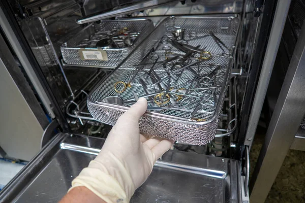 Bir hastanenin sterilizasyon bölümünde, cerrahi aletler çamaşır makinesine itilir.