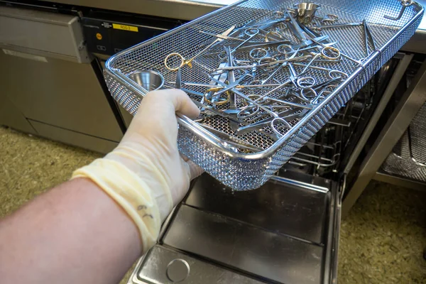 Bir hastanenin sterilizasyon bölümünde, cerrahi aletler çamaşır makinesine itilir.