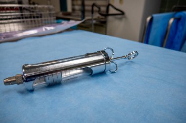 Bir araya getirilmiş idrar kesesi şırıngası mavi cerrahi tabanında yatıyor.