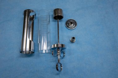 Parçalanmış ürolojik bir idrar kesesi şırıngası mavi bir işletim merkezinde yatıyor.