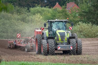 Bir traktör toprağa yeni tohumlar getirir.