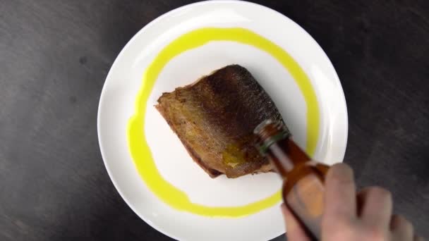 Piece of fried red fish on white plate rotates against black table. — Stock Footage Piece of fried red fish on white plate rotates against black table. Stock Footage