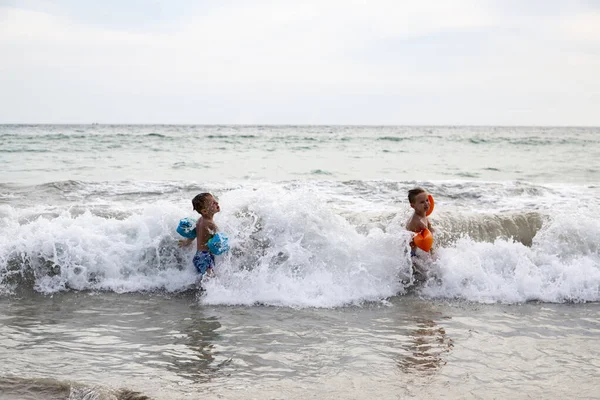 Kinder spielen im Meer auf den Wellen — Stockfoto