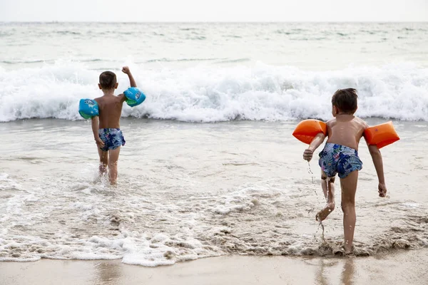 Gyerekek játszanak a tengerben a hullámokon — Stock Fotó