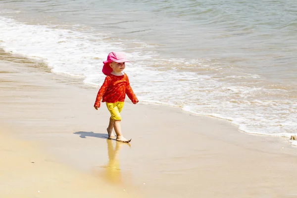 Küçük kız sahilde kum oynarken — Stok fotoğraf