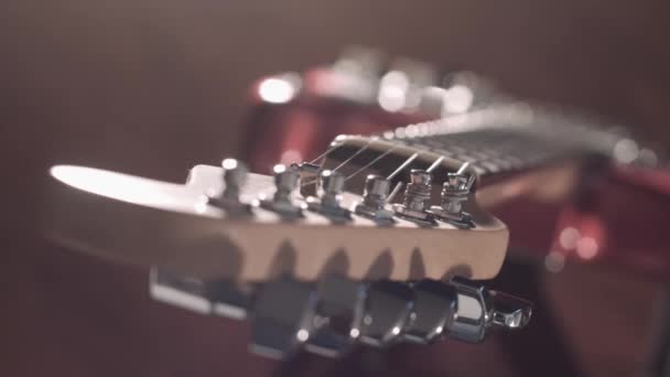 Filmiska fokusförskjutning på gitarr på scen, med naturliga signalljus blinkar — Stockvideo