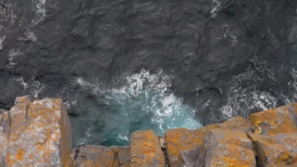 Meereswellen und orangefarbene Felsklippen, Draufsicht, Neigung — Stockvideo