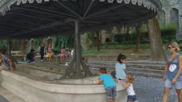 Menschen entspannen sich in der ikonischen Bergamos alten Waschplatz — Stockvideo