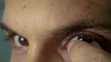 Genç adam kontakt lensler kaldırır