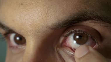 Genç adam kontakt lensler koymak
