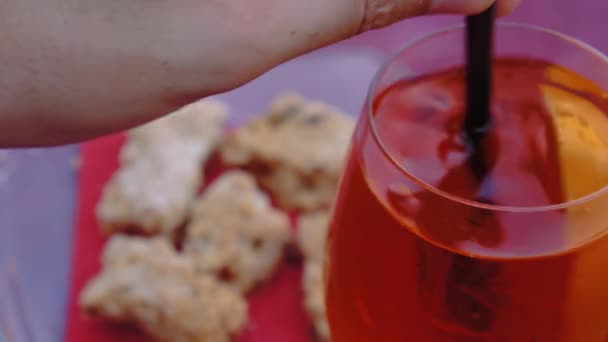 Man stirring spritz aperitivo with sbrisolona traditional Mantua cake in the background — Stock Video