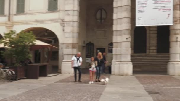 Brescia-Italien: fotgängare och cyklar i ”Corso Zanardelli” huvudgata, förbi Teatro Grande (stora teatern) — Stockvideo