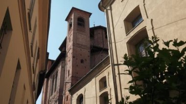 Eski kilise çan kulesi evler ve bir bitki Pavia, İtalya arasında ile