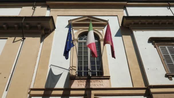 Banderas de universidades, italianas y europeas ondeando sobre la entrada de la Universidad de Pavía, Italia — Vídeos de Stock