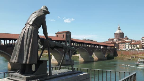 Pavia-Skyline und alte überdachte Brücke mit einem Boot, das auf dem Fluss Tticino fährt, Italien — Stockvideo