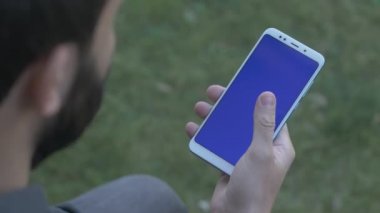 Adam yukarı ateş omuz üzerinden mavi ekran telefon, kaydırma