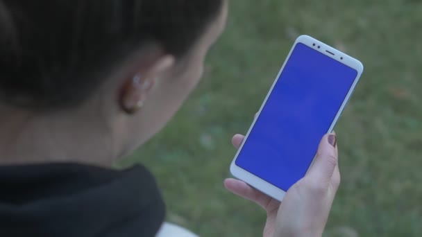 Chica deslizando lentamente teléfono de pantalla azul — Vídeos de Stock