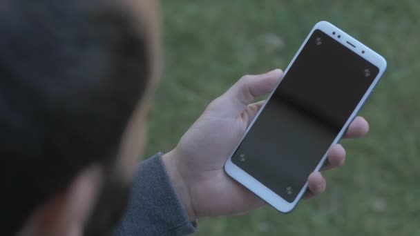 追跡ポイントと空白の画面携帯電話を保持している左利きの髭の男 — ストック動画