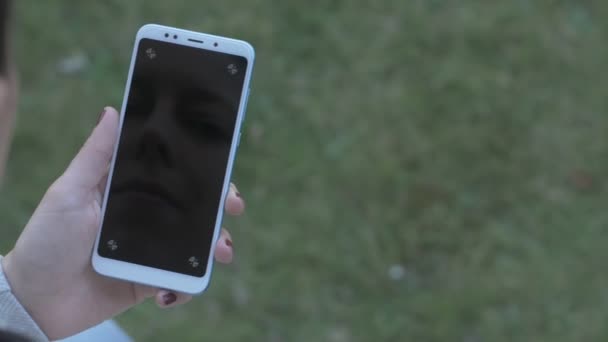 Imagen panorámica de una mujer sosteniendo un teléfono en blanco, con puntos de seguimiento — Vídeo de stock
