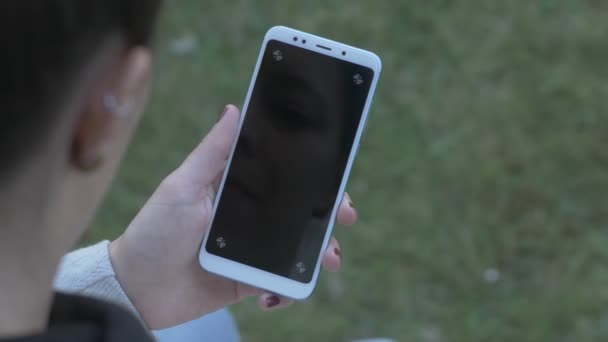 Mujer mirando en blanco, pantalla de teléfono rastreable, panorámica — Vídeos de Stock