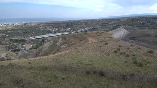 Órbita aérea disparada por encima de una colina con carretera en el fondo — Vídeo de stock