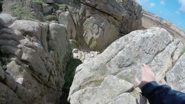 Mann klettert auf Felsen und zeigt das Meer am Horizont, Bretagne, Frankreich — Stockvideo