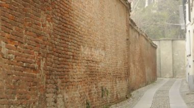 Orta kadeh kırmızı tuğla duvar ve Arnavut kaldırımı siste, sokak Pavia, Pv, İtalya