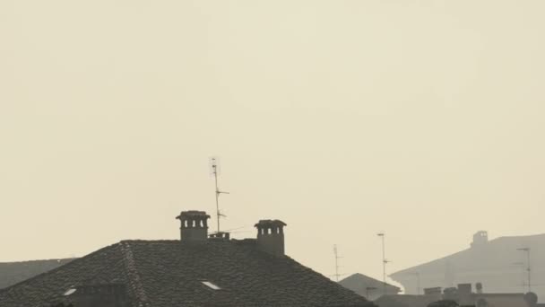 Μεσαίο πλάνο του στέγες σε την ομίχλη και τον καπνό από τις καμινάδες στην Παβία, Pv, Ιταλία — Αρχείο Βίντεο