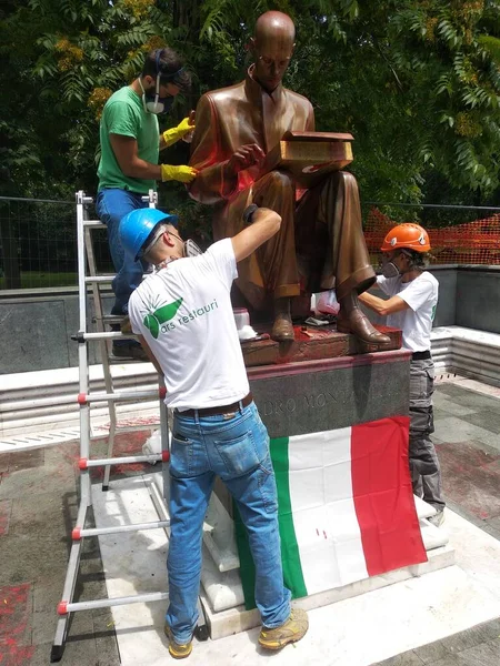 Milan, 15 Haziran 2020: Üç adam boyayla süslenmiş Indro Montanelli heykelini restore etti