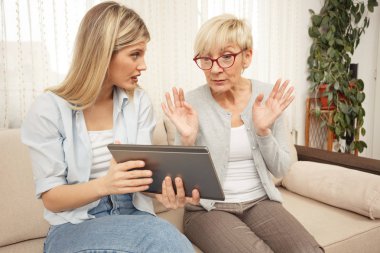 Anne ve kızı bir tablet vasıl bakarken hayran ve sürpriz