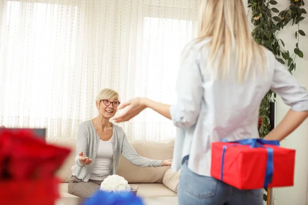 Annesi için hediye kutusu arkadan tutan genç kadın