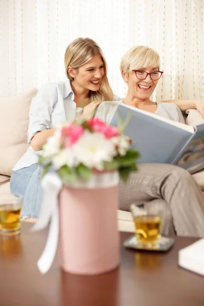 Mother and daughter looking at family photo album