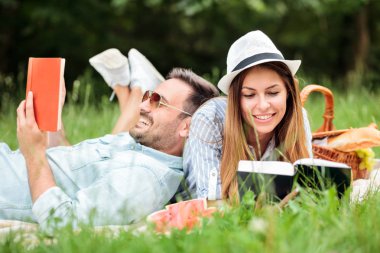 İyi bir zevk mutlu genç çift bir parkta piknik sırasında okuyun