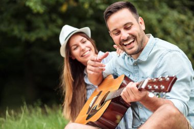 Mutlu genç adam onun güzel kız arkadaşı için gitar çalmak