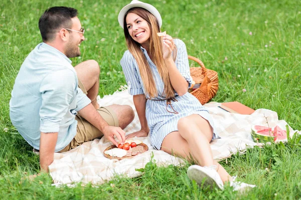 Hermosa joven pareja feliz disfrutando de su tiempo juntos en un picnic — Foto de Stock