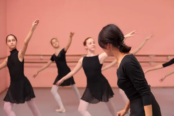 Połowy nauczyciel dorosłych kobiet balet polecająca średniej grupy nastoletnich dziewczyn — Zdjęcie stockowe