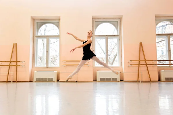 Teenage balerína cvičí balet se pohybuje ve velké taneční studio — Stock fotografie