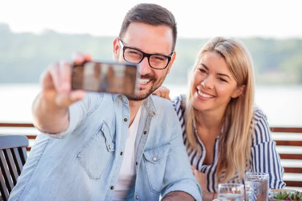 Feliz joven pareja tomando una selfie en un café — Foto de Stock