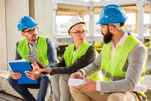 Equipo de jóvenes arquitectos exitosos discutiendo detalles del proyecto durante una reunión — Foto de Stock