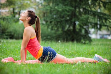 Şehir parkında yoga yapan fit genç kadın