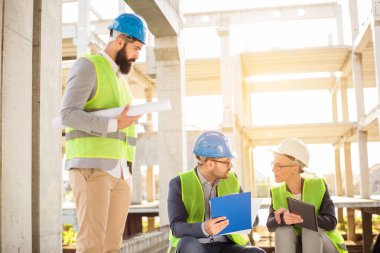 Başarılı genç mimarlar ve iş ortaklarından oluşan ekip bir şantiyede gayri resmi bir toplantı yapıyor