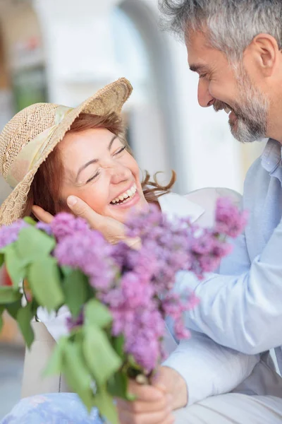 Esposo sorprende a su esposa con un ramo de lilas — Foto de Stock