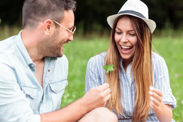Sonriendo feliz pareja joven pasar tiempo juntos en un picnic en el parque — Foto de Stock