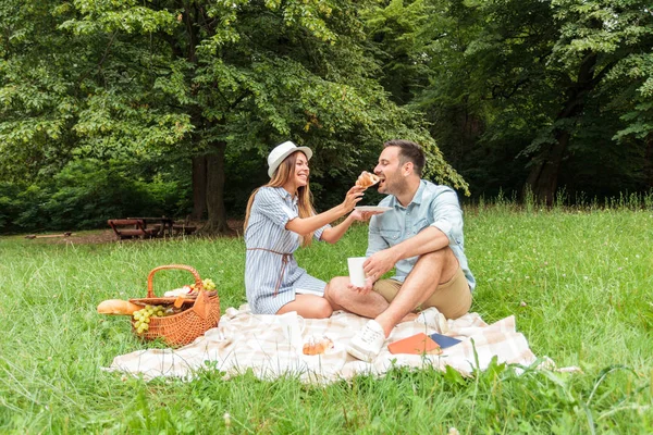 Hermosa pareja joven teniendo un picnic relajante en un parque — Foto de Stock