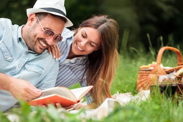 Hermosa pareja joven teniendo un relajante picnic romántico en un parque — Foto de Stock