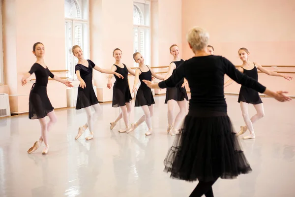 高级芭蕾舞教练在一群少女面前展示动作 — 图库照片