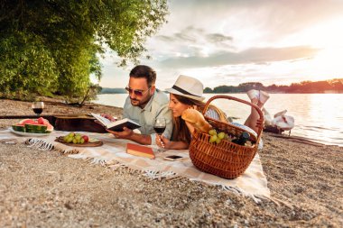 Mutlu genç çift bir plajda rahatlatıcı, piknik battaniye üzerinde yalan