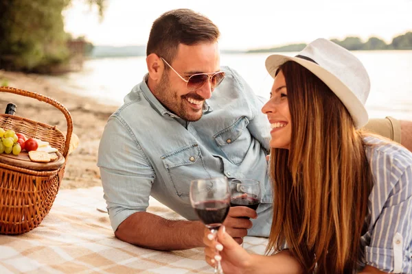 Bella giovane coppia godendo pic-nic su una spiaggia — Foto Stock