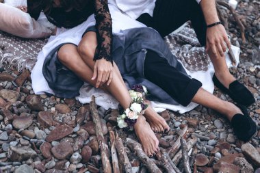 A couple in love are sitting on the beach with flowers. clipart